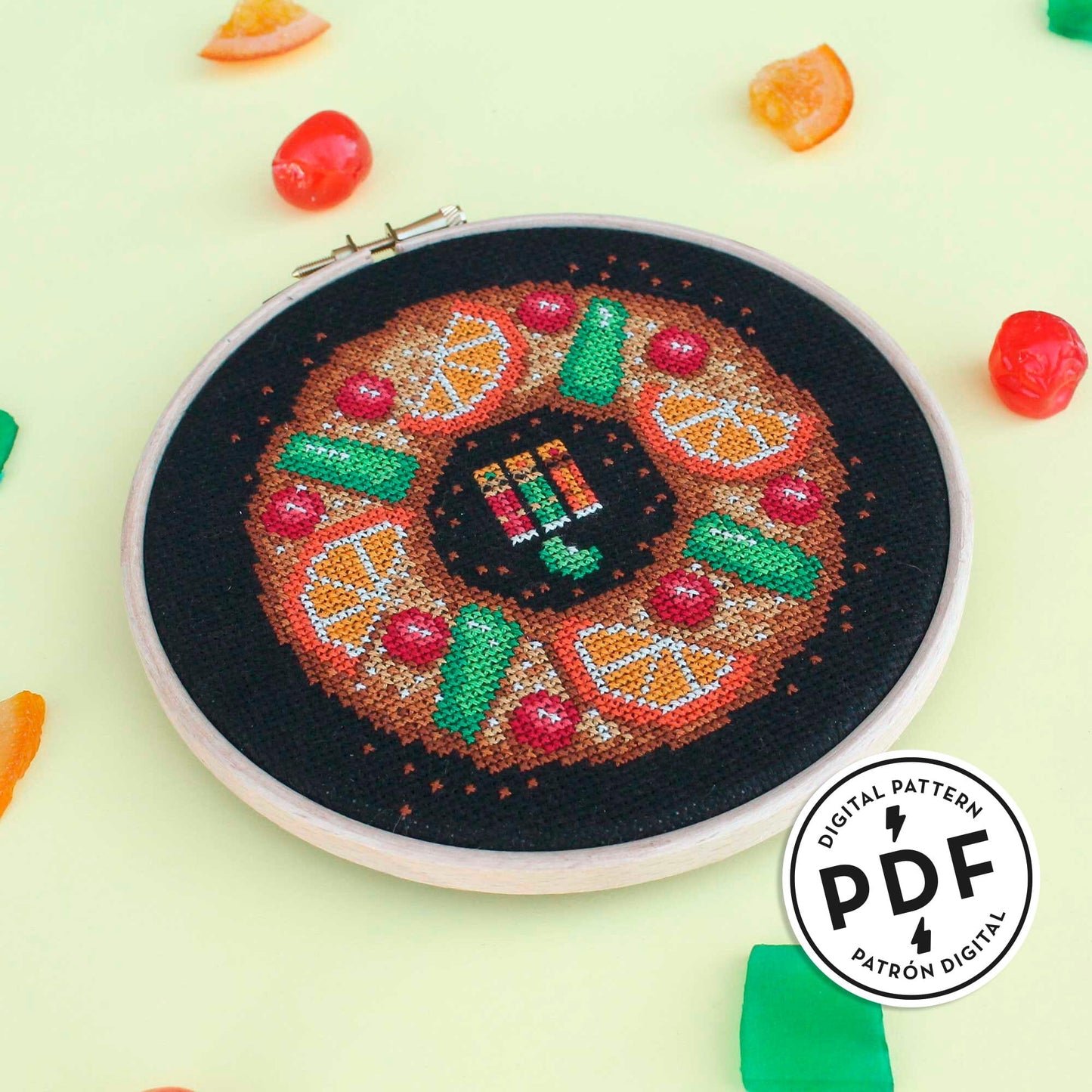 Esquema de punto de cruz en PDF de un roscón de reyes. El roscón tiene fruta por encima y las figuras de los reyes magos y el haba están en el centro.