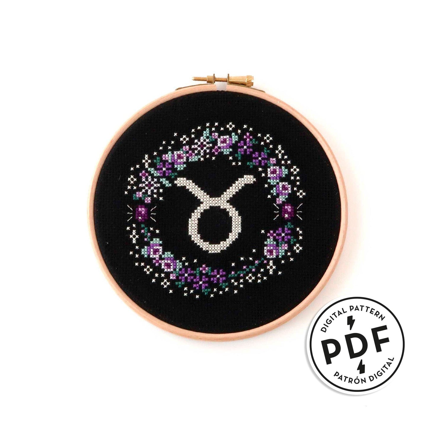Patrón de punto de cruz en PDF con el signo de Tauro rodeado de flores en tonos de lila. Signo del zodíaco de punto de cruz moderno y redondo para enmarcar en aro de bordar.